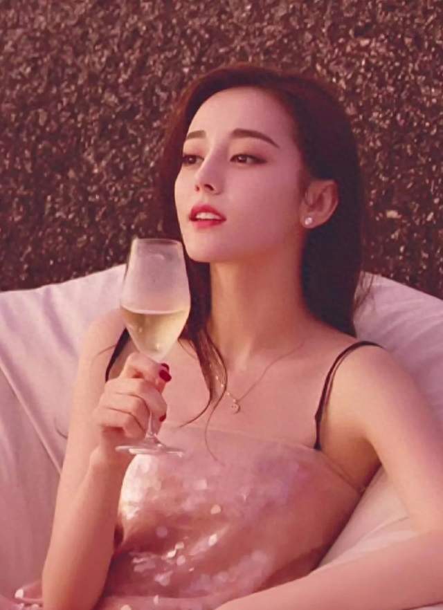 迪丽热巴坐在沙发上拿着香槟看风景，穿吊带裙太有气质了！ ???