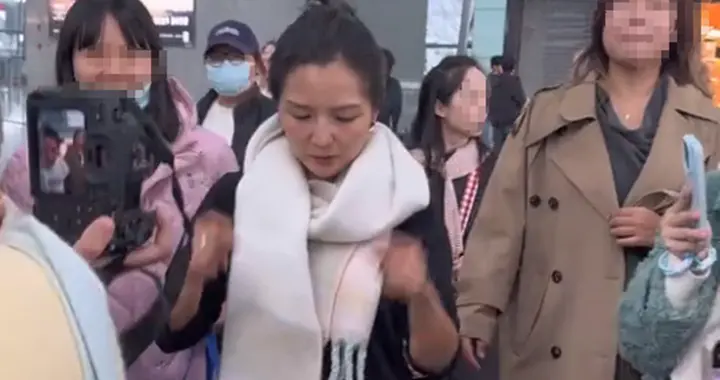 何洁现身机场，穿衣打扮保持20年前审美，素颜黑又显老撞脸郑佩佩
