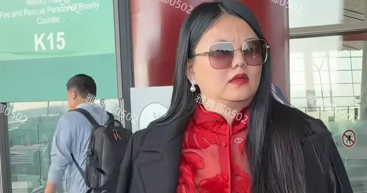 李湘现身北京机场，她一身大红色套装披着黑色大衣，贵妇范儿十足