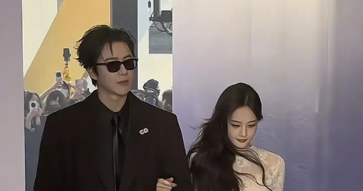 李一桐一袭白色长裙，优雅动人。二人挽手同行