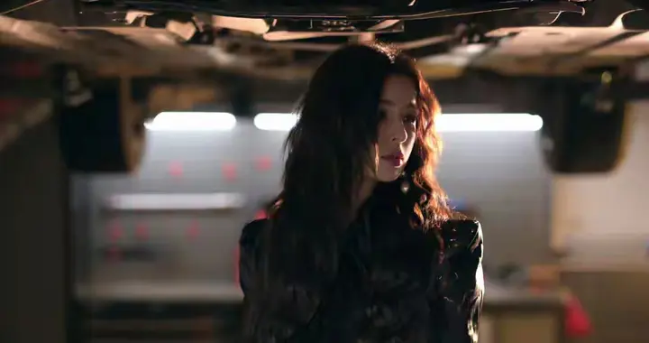 哈妮克孜｜身处汽修场景，身着黑色皮衣、蕾丝内搭与皮短裤