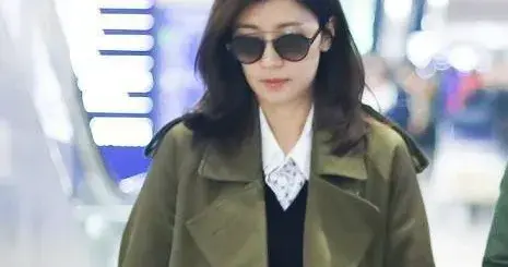 贾静雯机场私服真时髦！军绿色大衣+小黑裙+长筒靴，高级又洋气！