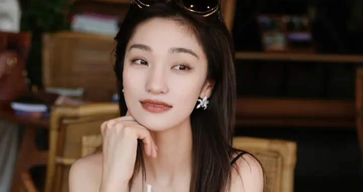 主持人蓝羽手捧椰汁拍美照，一袭吊带裙配长发，惬意又漂亮