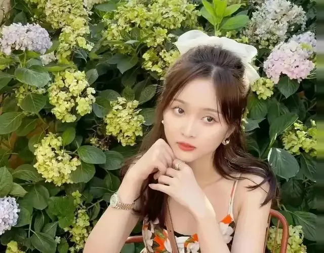 坐于花丛中像一个花仙子？吴宣仪穿印花吊带裙配高马尾