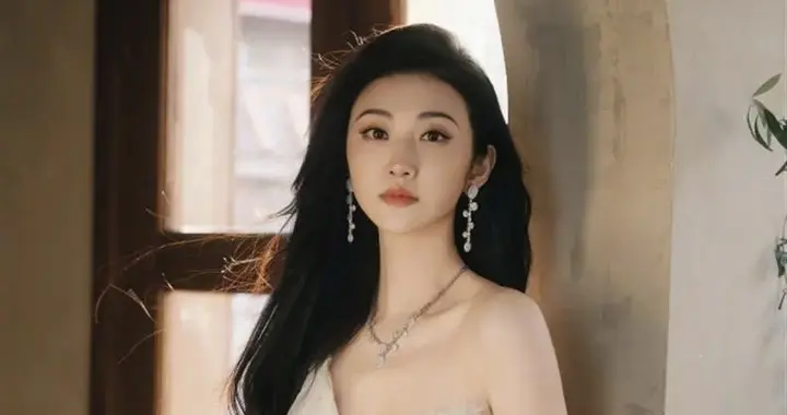 景甜一袭白色薄纱裙在阳光下写真，明媚动人。