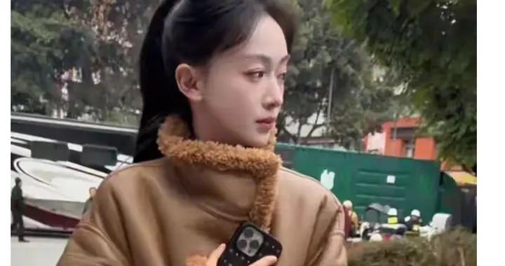 吴谨言一身卡其色大衣，衬托出苗条的身材，扎着高马尾，显年轻。