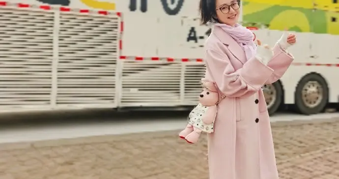 主持人杜悦穿着粉色大衣配棕红色打底袜活力满满