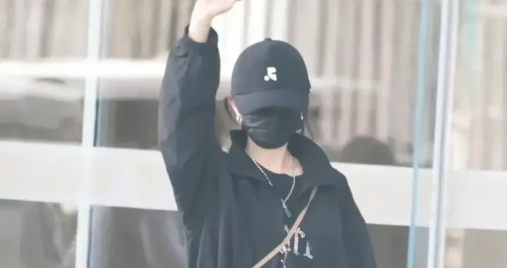 杨幂穿上高筒靴了，不惧腿弯很自信，她穿白色短裙背小熊包很俏皮