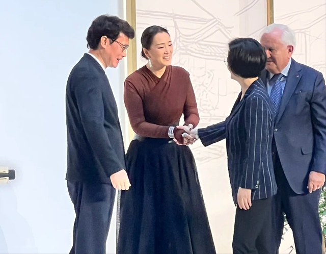 巩俐回国参加活动，穿黑色裙摆超优雅，还双手握对方单手很有礼貌