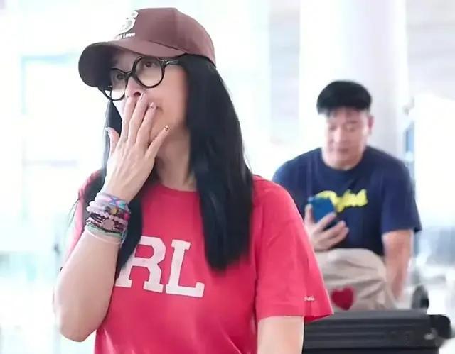 57岁那英最新机场穿搭：红短袖+牛仔裤+帆布鞋，减龄又时尚