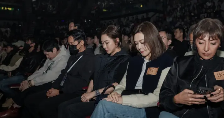 关之琳看演出为火灾默哀，低头坐着表情凝重，上山诗钠在旁看手机