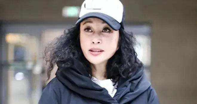 刘晓庆真是奶奶辈穿搭标杆！穿黑色羽绒服+棒球帽，时髦又减龄！