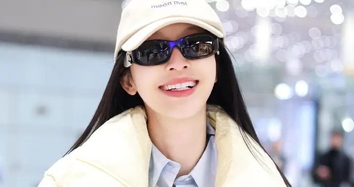 张俪最新机场美照，穿奶黄色羽绒服戴着墨镜，长发飘飘又美又温柔