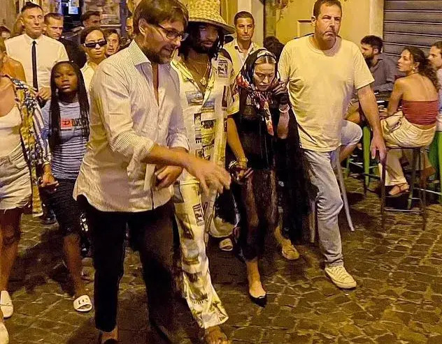 66岁麦当娜意大利游玩，被28岁男友牵手难掩疲态，引发网友热议！