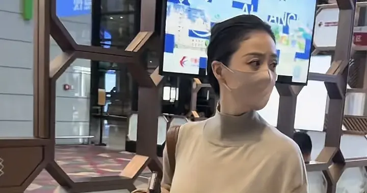 蒋欣机场浅棕色高领针织衫，搭配同色系下装，整体风格简约大气