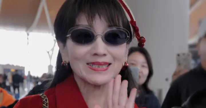 赵雅芝上海出发机场路透，穿红色长款大衣戴贝雷帽，喜庆又洋气