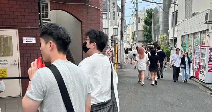 毛不易在日本表参道逛街，他的身材有点胖，个子挺矮的