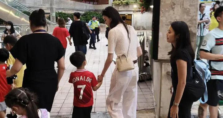 奚梦瑶带5岁儿子看球赛，蹲着帮儿子整理仪容，两人牵着手好有爱