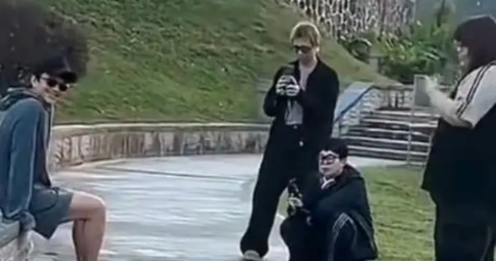 邓超广东被偶遇，穿拖鞋大裤衩坐花坛边，与粉丝合影姿势好妖娆