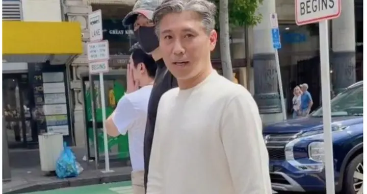 51岁李乃文现身新西兰，他穿白色卫衣，头发花白，状态不错。