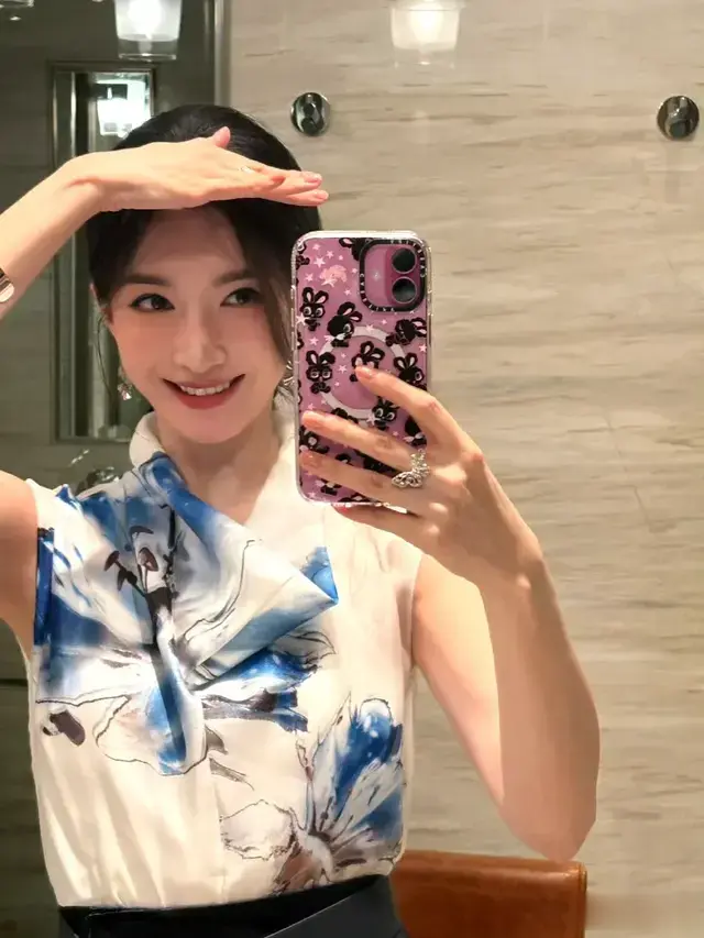 江疏影身着蓝白花纹的无袖上衣，笑容灿烂，眉眼弯弯，自拍