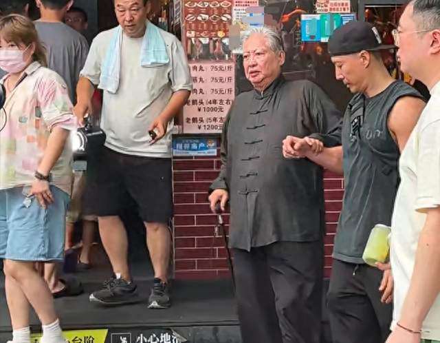 洪金宝在汕头吃鹅肉饭，走路蹒跚，身材臃肿，需要儿子洪天照搀扶