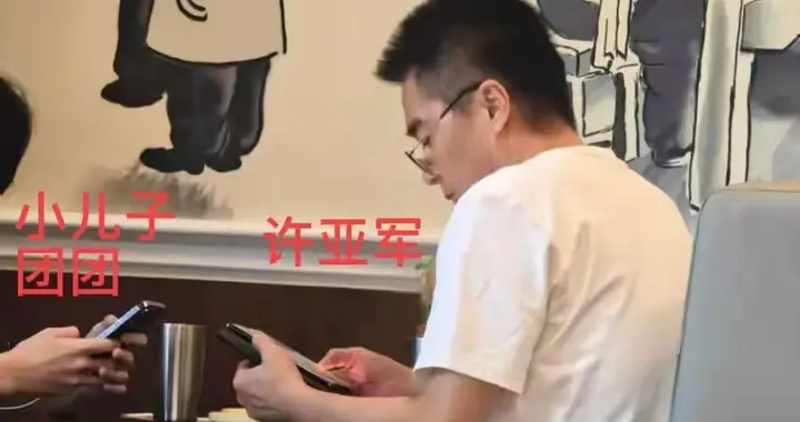 何晴去世后许亚军首现身美国！白衣老花镜盯手机，陪小儿子吃中餐