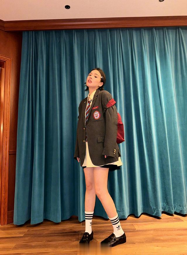 马思纯扮“学生妹”，一身制服穿搭搭百褶裙，双扎短马尾，很俏皮