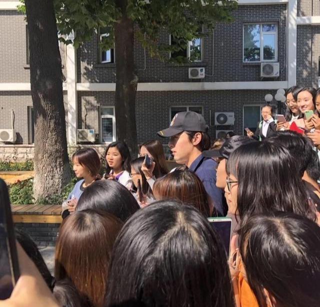 胡歌现身中传被迷妹包围，37岁颜值堪比小鲜肉，穿连体裤像电工