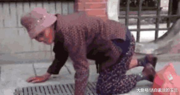 年迈老太太趴在下水井盖旁将食物往里放，上前看清后打119了