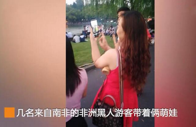 黑人游客带娃游西湖，无奈被路人当成风景拍，只得挂牌“合影10元一次”