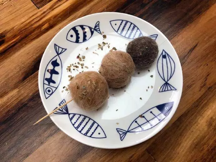 某铲屎官用猫脱落的毛做了一串丸子，骗猫吃...