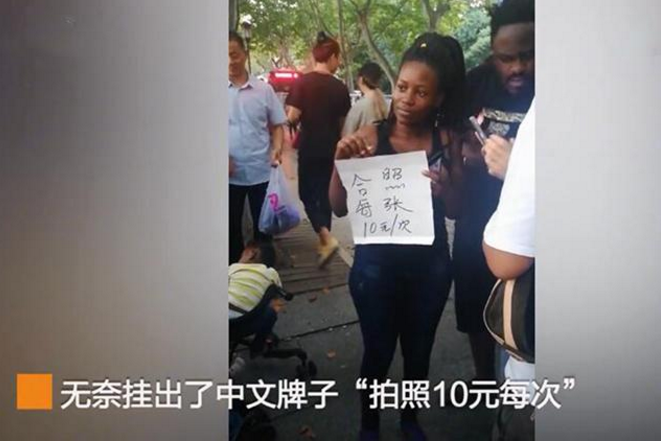 黑人游客带娃游西湖，无奈被路人当成风景拍，只得挂牌“合影10元一次”