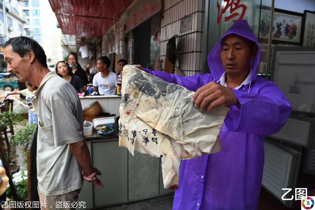 乙图|洪水退去后歙县居民自救，看到祖传族谱和字画被泡，老人哭了