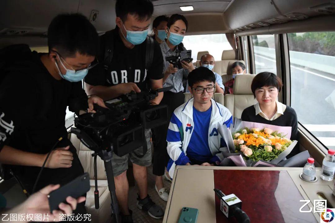 乙图|援鄂护士送儿子到武汉报到，被鲜花和记者包围，儿子被阵势吓懵了