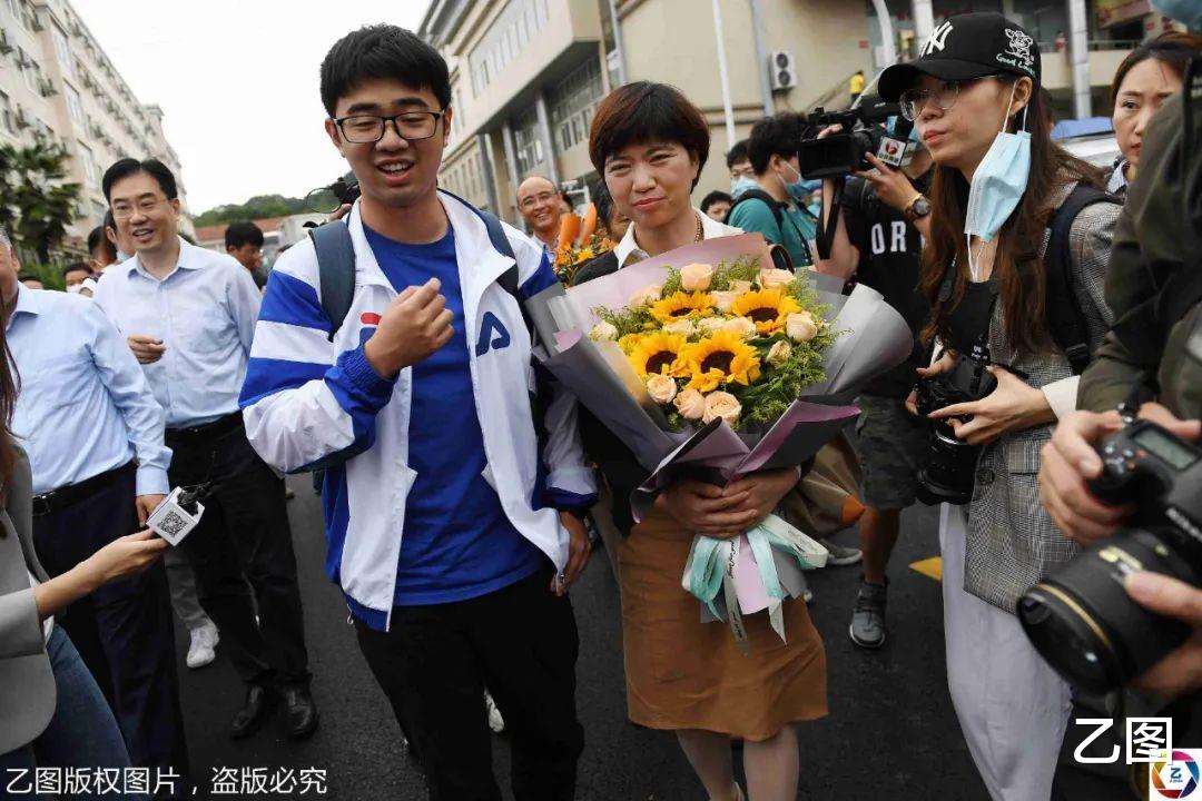乙图|援鄂护士送儿子到武汉报到，被鲜花和记者包围，儿子被阵势吓懵了