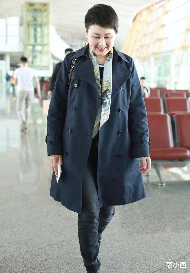 [风衣]张凯丽哪像57岁！剪了超短发穿风衣配丝巾走机场，时髦上升一个度