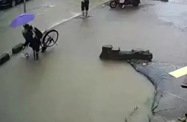 ?天天正能量官方|暴雨中背书包女孩被暗坑吞没，他们为救人连鞋都跑丢了……英雄现身了！