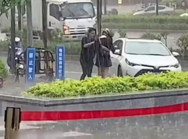 亚洲播报一姐 广西南宁暴雨突袭，俩女子街头淡定洗头，网友：做了我一直想做的事