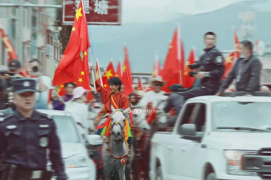 时尚风行派|丁真骑白马上街超有排面！穿藏袍举国旗意气风发，笑容好有感染力