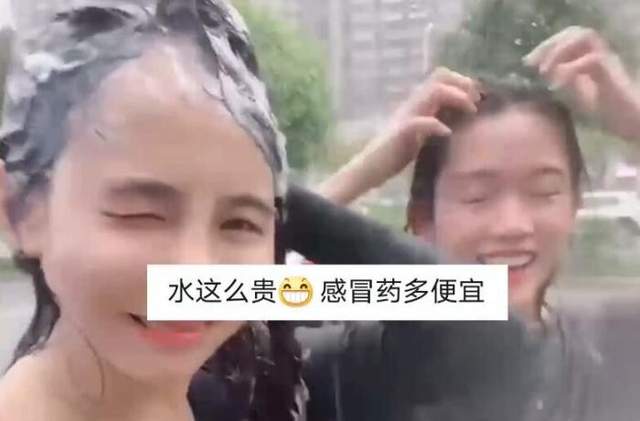 亚洲播报一姐 广西南宁暴雨突袭，俩女子街头淡定洗头，网友：做了我一直想做的事
