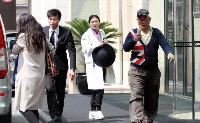 张艺谋|张艺谋娇妻保养得真好！穿白色大衣混搭运动鞋气质满分，漂亮大气