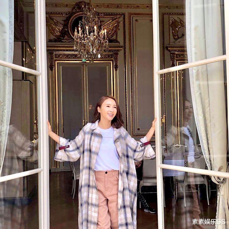 黎姿|黎姿站在落地窗前拍照，身后的维港风景很美，过着富太太般的生活