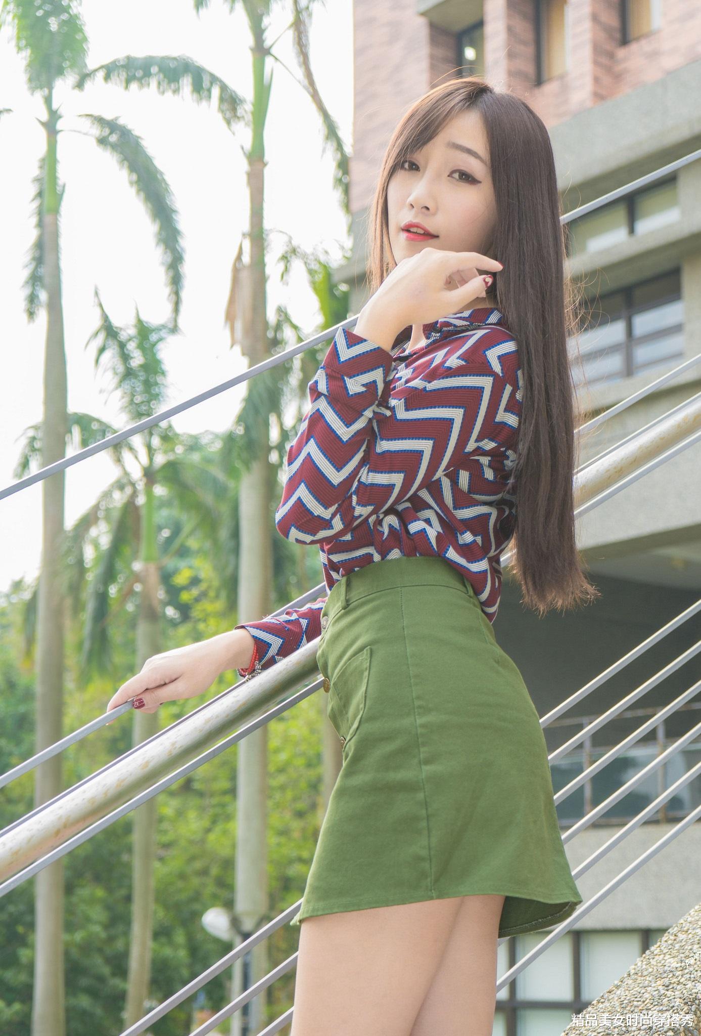 |W条纹衬衫下搭一条军绿色短裙，整套搭配OL知性范儿十足。