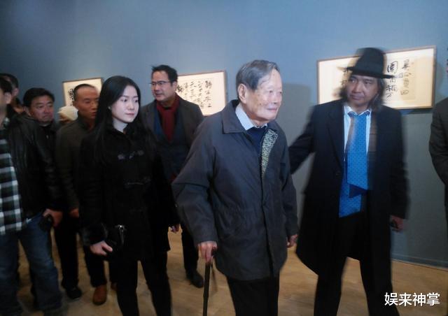 杨振宁|99岁杨振宁身形消瘦！拄拐杖依旧精神昂扬，娇妻年轻靓丽紧紧跟随