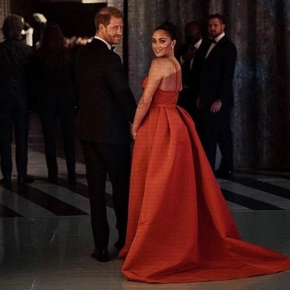 爱心|梅根穿红裙闪耀红毯！爱心领大方露肉，与哈里全程十指紧扣好恩爱