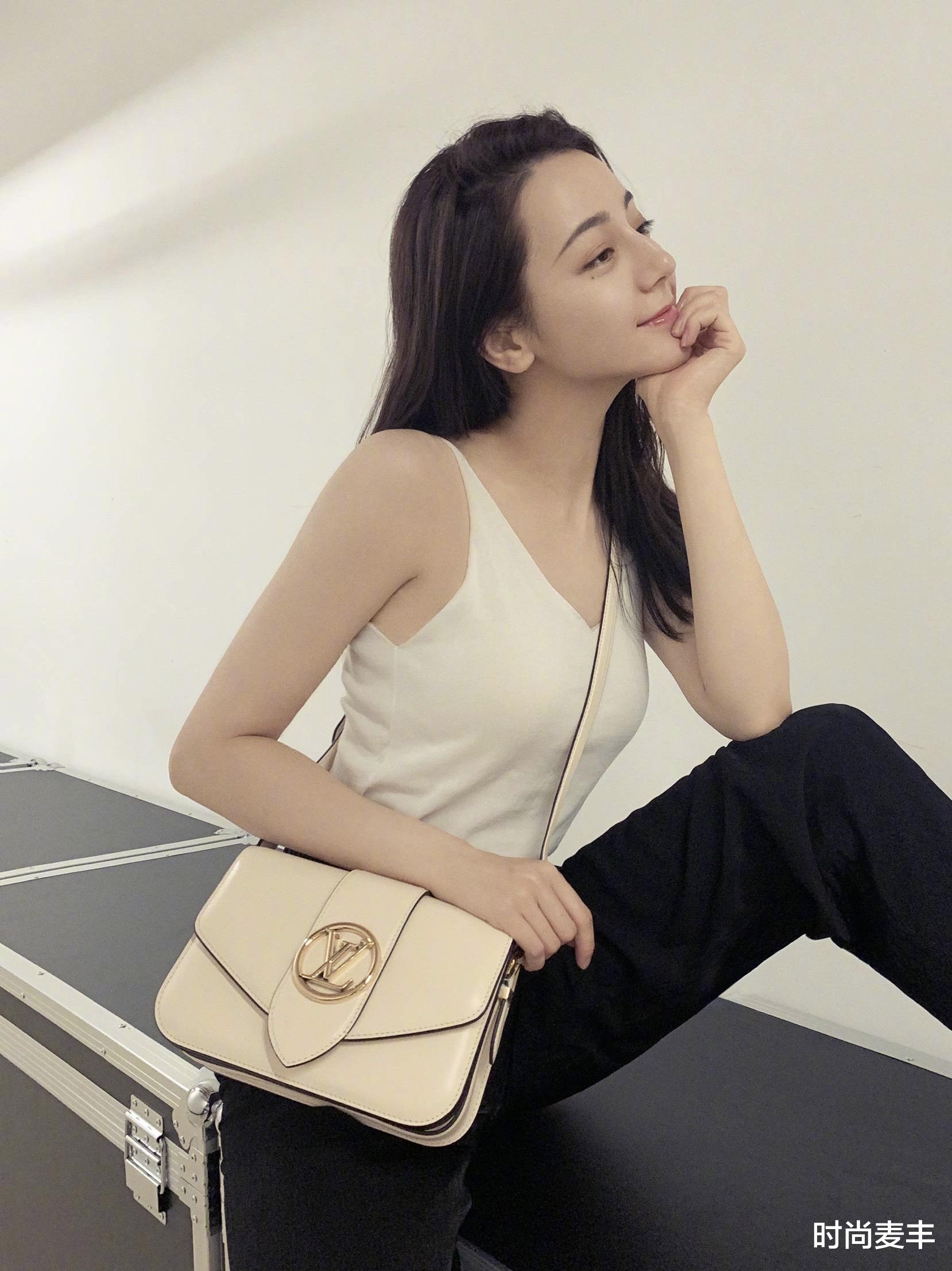 时尚麦丰|迪丽热巴机场饭拍图，黑色印花深v连衣裙曲线优美，行走的衣架子