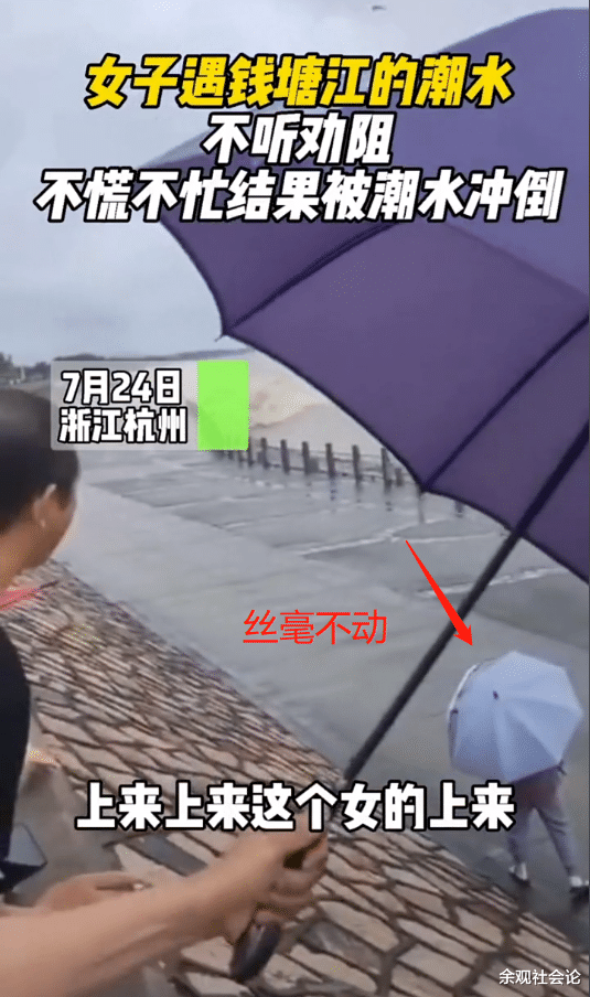 钱塘江 女子看钱塘江大潮，面对众人大喊“上岸”装听不见，结果被冲跑了