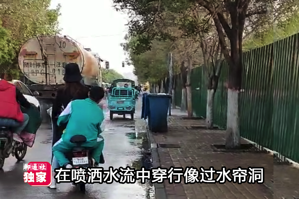 聊通社 山东茌平一路口洒水车长时滞留,停车不停水,市民穿行如过水帘洞
