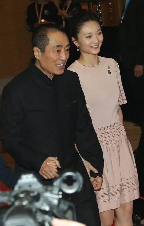 张艺谋|张艺谋娇妻真没法低调，穿衬衫配硕大钻石耳环，水钻珍珠包更抢眼